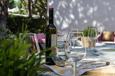 a bottle of wine sitting on a table with glasses at Casa da Aldeia in Albufeira