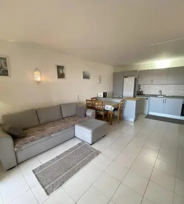 a living room with a couch and a table and a kitchen at House Т1 Bella Vista in Albufeira