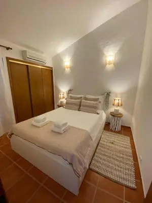 a bedroom with a large white bed with two lamps at Beach Villa Alfamar Praia da Falésia in Albufeira
