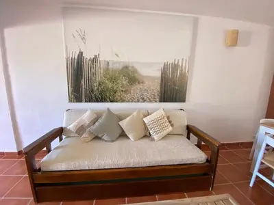 a couch sitting in a room with a painting on the wall at Beach Villa Alfamar Praia da Falésia in Albufeira