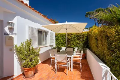 a patio with a table and an umbrella at Vila Senna in Vale do Lobo