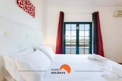 a bedroom with a large white bed with a window at #146 Summer House A6 by Home Holidays in Ferreiras