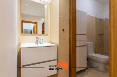 a bathroom with a sink and a toilet and a mirror at #146 Summer House A6 by Home Holidays in Ferreiras
