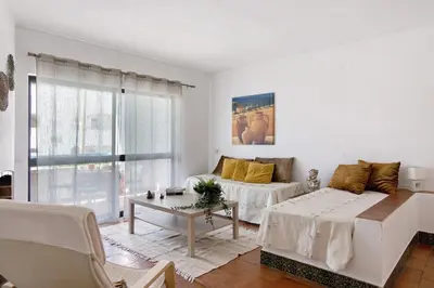 a white living room with a couch and a table at Mar azul 3 in Albufeira
