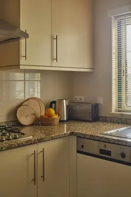 a kitchen with white cabinets and a counter top at Casa Terra with Pool & Free WiFi in Albufeira