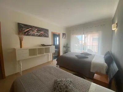 a bedroom with two beds and a dresser and a window at Villa Jardins 3 by Sunny Deluxe in Albufeira
