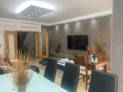 a living room with a table and chairs and a television at Villa Jardins 3 by Sunny Deluxe in Albufeira