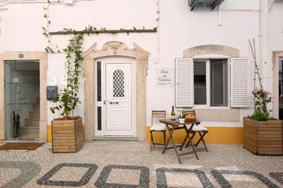 a patio with a table and chairs in front of a building at Casa na Travessa 2 in Faro