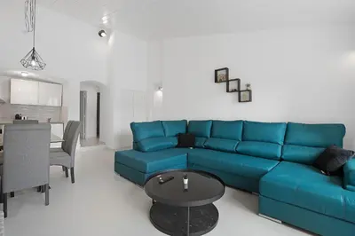 a living room with a blue couch and a table at Poolside Villa Sereno in Albufeira