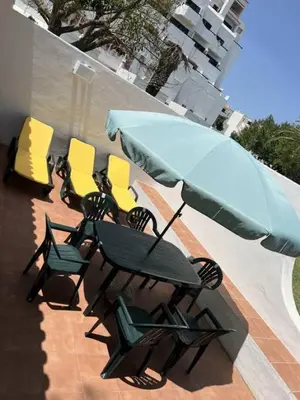 a group of chairs and an umbrella on a patio at Poolside Villa Sereno in Albufeira