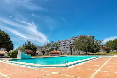 a swimming pool with a building in the background at Poolside Villa Sereno in Albufeira