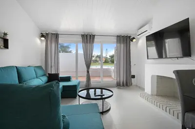 a living room with a blue couch and a table at Poolside Villa Sereno in Albufeira