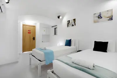 two beds in a room with white walls at Poolside Villa Sereno in Albufeira