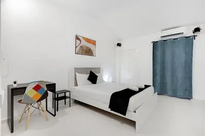 a white bedroom with a bed and a desk at Poolside Villa Sereno in Albufeira