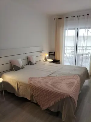 a bedroom with a large bed with a brown blanket at T2 Vista Atlantica 3 minutos da praia de Quarteira in Quarteira