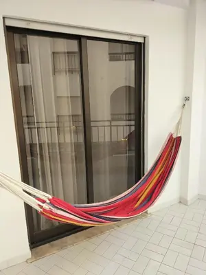 a hammock is hanging in front of a window at T2 Vista Atlantica 3 minutos da praia de Quarteira in Quarteira