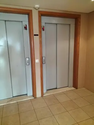 three glass doors in a room with a tile floor at T2 Infante AC wifi Garagem 50m Praia in Quarteira