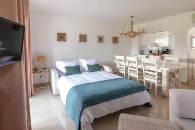 a bedroom with a bed and a dining room at Moradia Olhos de Água - 3 quartos - 6 camas in Albufeira