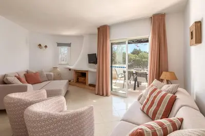 a living room with a couch and chairs and a television at Moradia Olhos de Água - 3 quartos - 6 camas in Albufeira