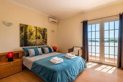 a bedroom with a bed and a large window at Villa Chris by Gabi Miguel in Albufeira