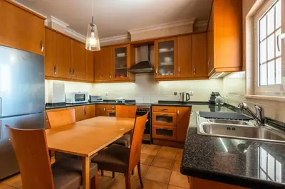 a kitchen with a wooden table and a sink at Villa Chris by Gabi Miguel in Albufeira