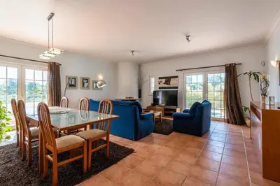 a living room with a table and blue chairs at Villa Chris by Gabi Miguel in Albufeira