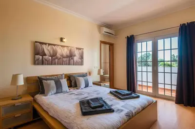 a bedroom with a large bed with two towels on it at Villa Chris by Gabi Miguel in Albufeira