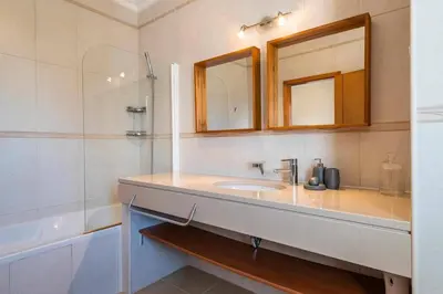 a bathroom with a sink and a mirror and a tub at Villa Chris by Gabi Miguel in Albufeira