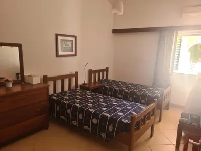 a bedroom with two beds and a dresser and a mirror at Vilamoura Alecrim in Vilamoura