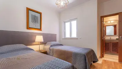 a hotel room with two beds and a mirror at Greice Homes-2 bedroom penthouse Vilamoura in Quarteira