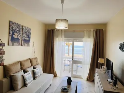 a living room with a white couch and a television at Julias Beach Retreat in Quarteira