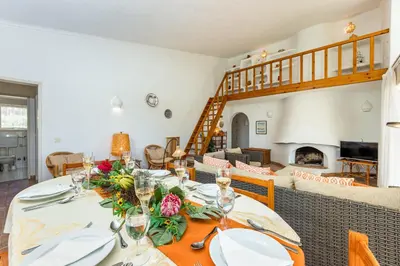 a dining room with a table and a fireplace at Villa Bolota in Albufeira