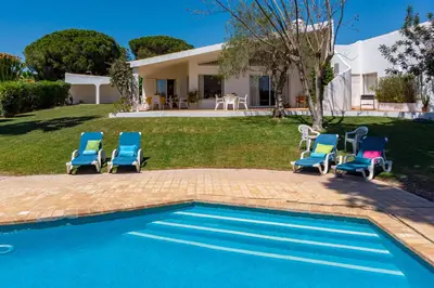 a group of chairs sitting next to a swimming pool at Villa Bolota in Albufeira
