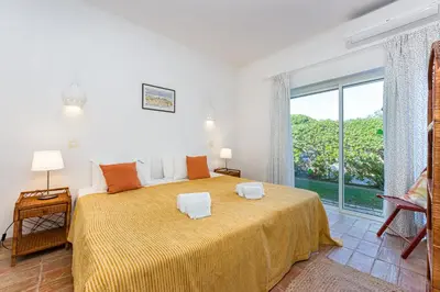 a bedroom with a large bed and a large window at Villa Bolota in Albufeira