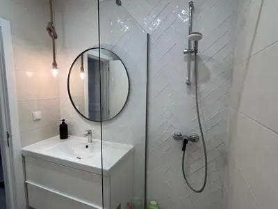 a bathroom with a shower with a sink and a mirror at Vilamoura Neptuno Apartment in Vilamoura