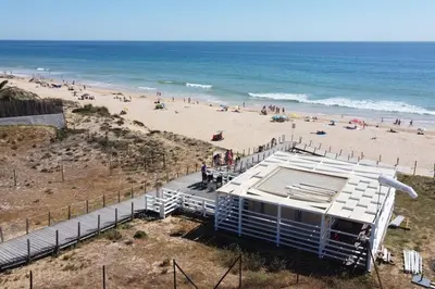 a view of a beach with a building and people at Charming Beachside Apartment- The Perfect Getaway! in Albufeira