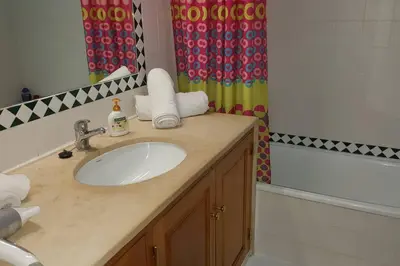 a bathroom with a sink and a shower curtain at Charming Beachside Apartment- The Perfect Getaway! in Albufeira