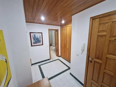 a hallway with a wooden door and a white tile floor at Charming Beachside Apartment- The Perfect Getaway! in Albufeira