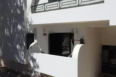 a white building with a balcony and a door at Charming Beachside Apartment- The Perfect Getaway! in Albufeira