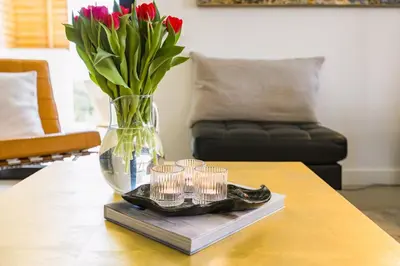 a vase with flowers and candles on a table at Luxury 3-Bed Penthouse with Ocean Views, Terrace & Pool in Quarteira