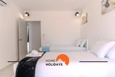 a room with two beds with a home holidays sign on it at #265 Charming Villa Sam in Albufeira