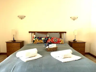 a bed with two towels and a basket on it at Coastal Greens by Seareen in Quarteira