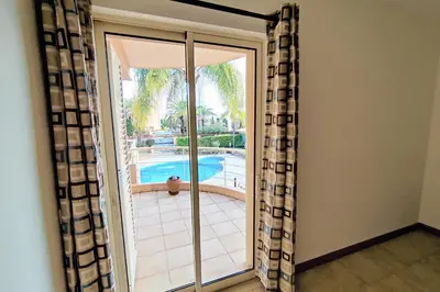 a sliding glass door with a view of a swimming pool at Coastal Greens by Seareen in Quarteira