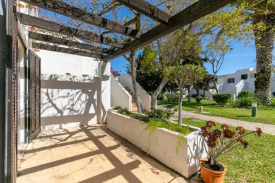 a patio with a pergola and plants in a yard at Balaia Golf Poolside Retreat - Superior 2 bed villa in Albufeira