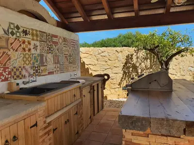 a kitchen with a sink and a stone wall at Real Village in Quarteira