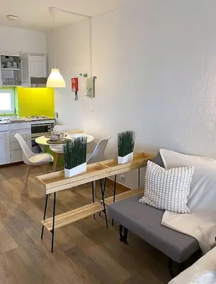 a living room with a table and a couch and a kitchen at Studio with great sea view, near the beach, with AC and pools in Albufeira