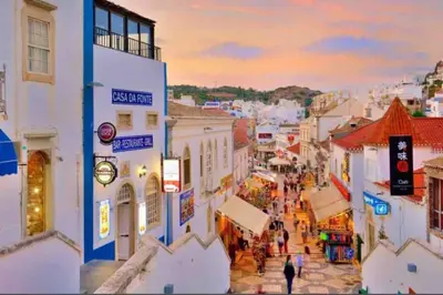 a group of people walking down a city street at Studio with great sea view, near the beach, with AC and pools in Albufeira