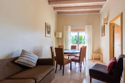 a living room with a couch and a table and chairs at Casa Colina in Albufeira