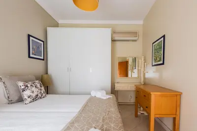 a bedroom with a bed and a dresser and a mirror at Casa Colina in Albufeira