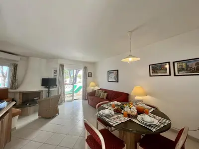 a living room with a table and a couch at Albufeira Balaia Golf Vilage 2 With Pool by Homing in Albufeira